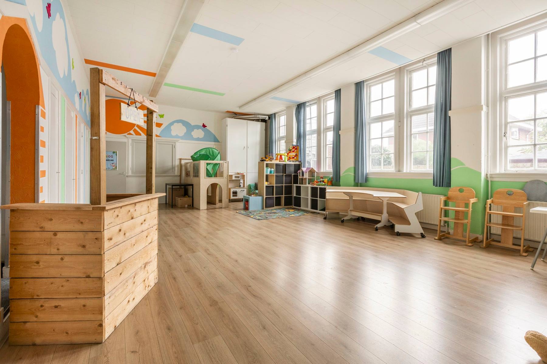 A bright children's room in the Zuiderkerk, with a painted mural and low furniture.