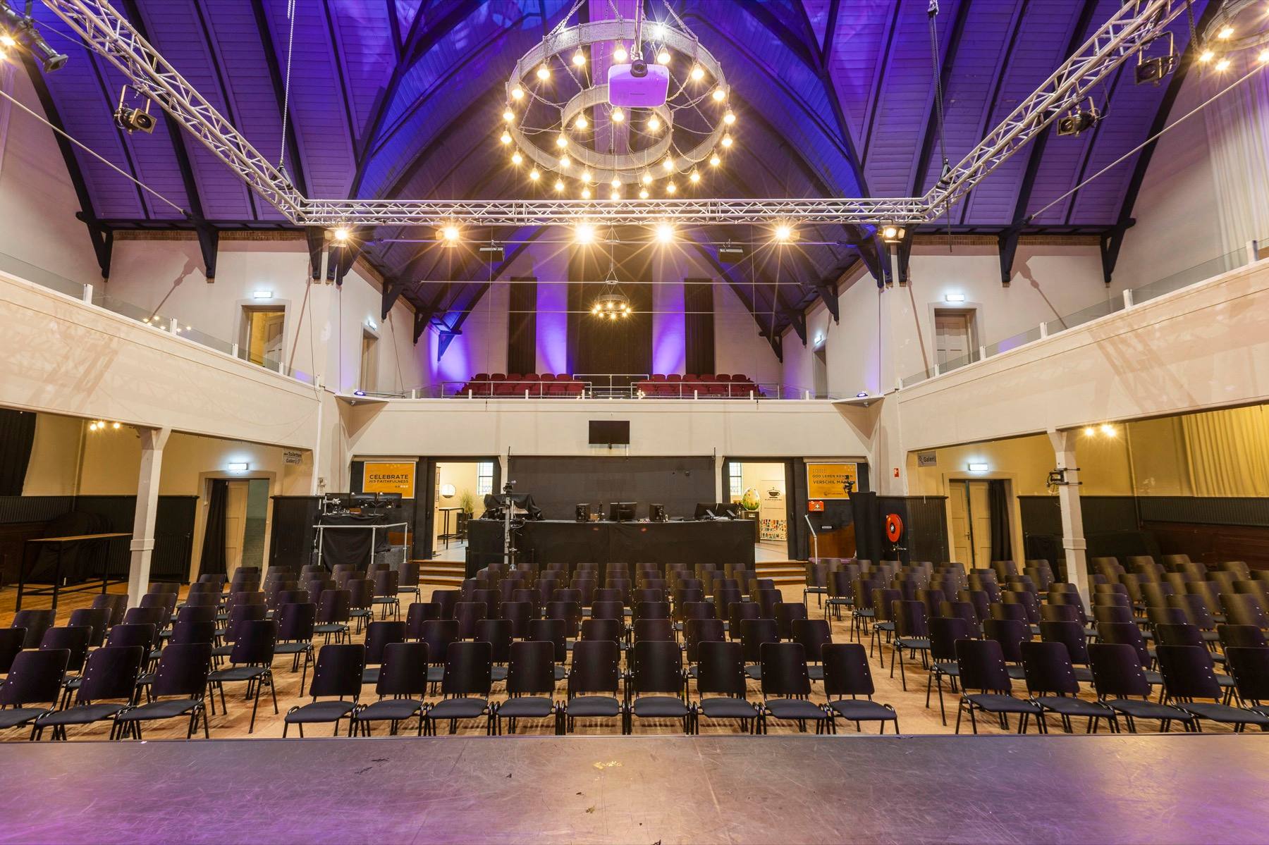 The main hall of the Zuiderkerk, seating laid out towards the stage beneath the timber roof.