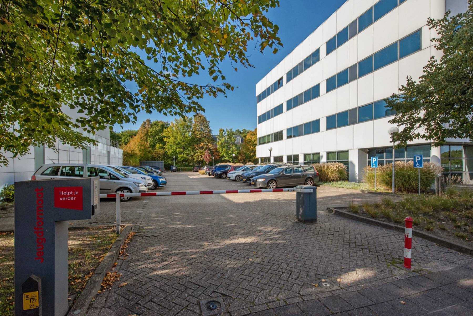 The approach to Fleminglaan 12, with the tenant's sign at the entrance to the car park.