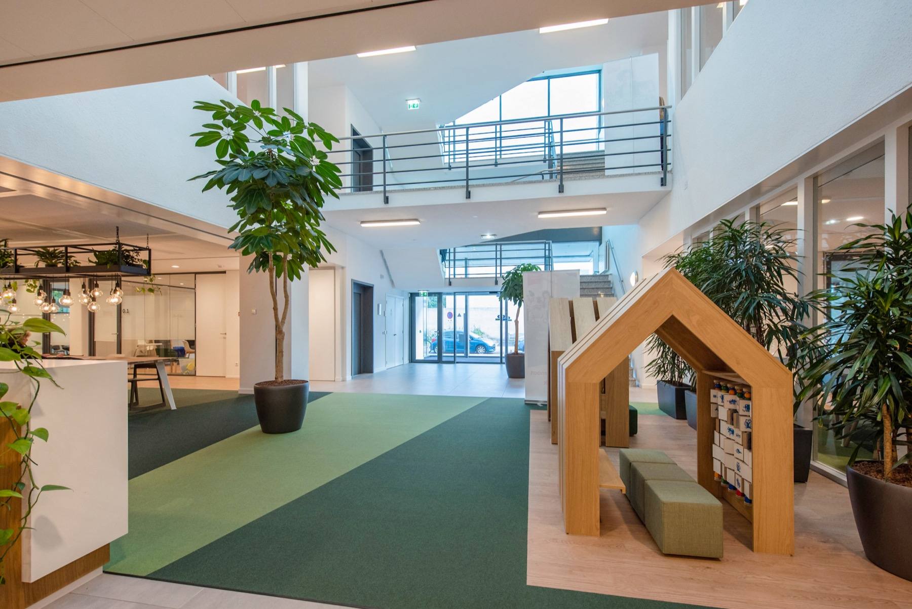 The open ground floor of the atrium, with planting and a timber play house for the tenant's visitors.
