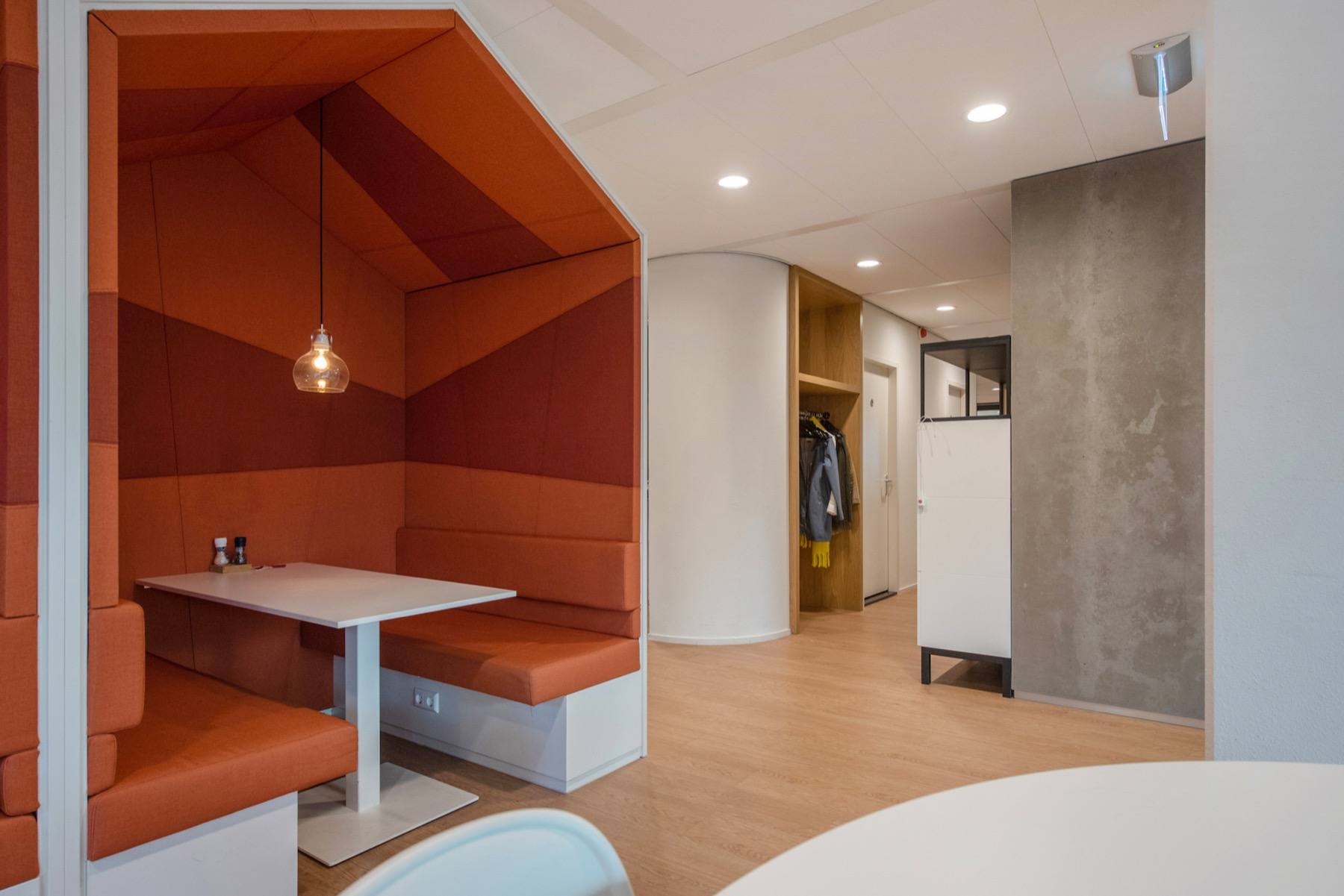 An upholstered break-out booth beside the building's café area.